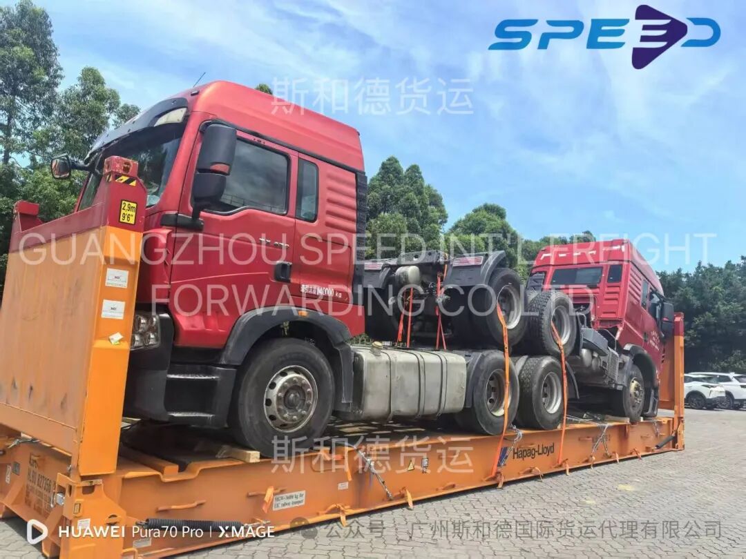 Two heavy tractor trucks stacked on a single flat rack container